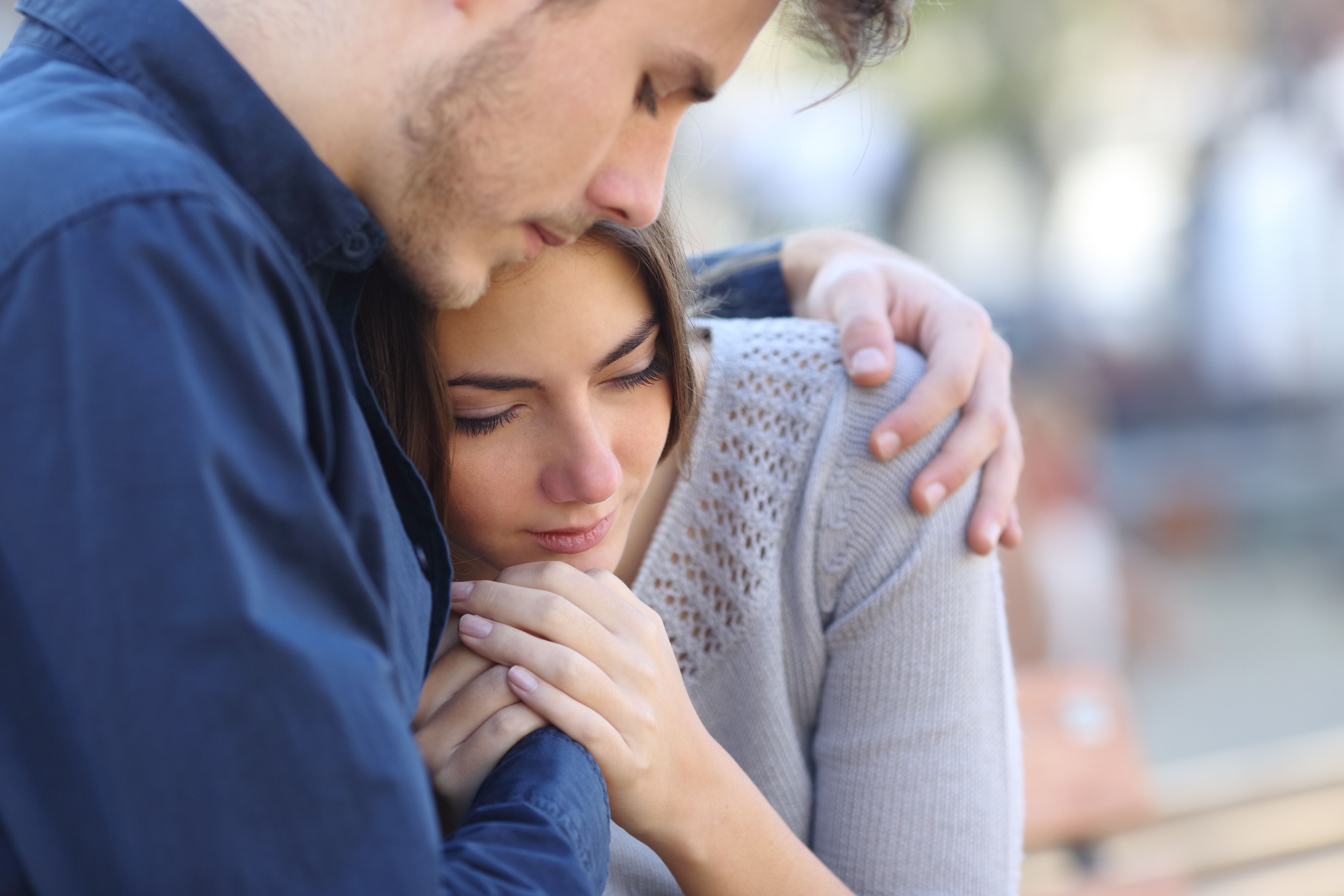 Young man hugging woman