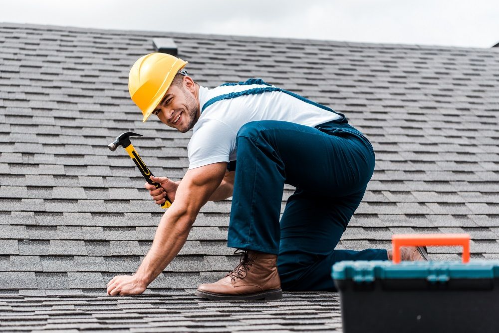 Roofer Working on Metal Roofing contractors naples fl