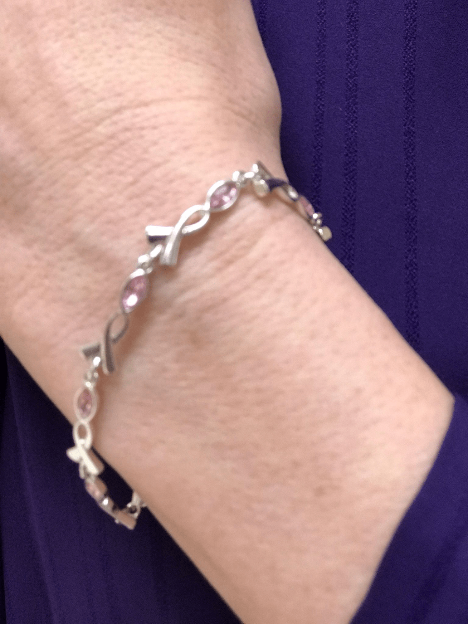 April wears a breast cancer awareness bracelet.