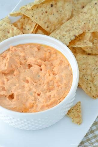 A pile of chips next to pimento cheese dip.