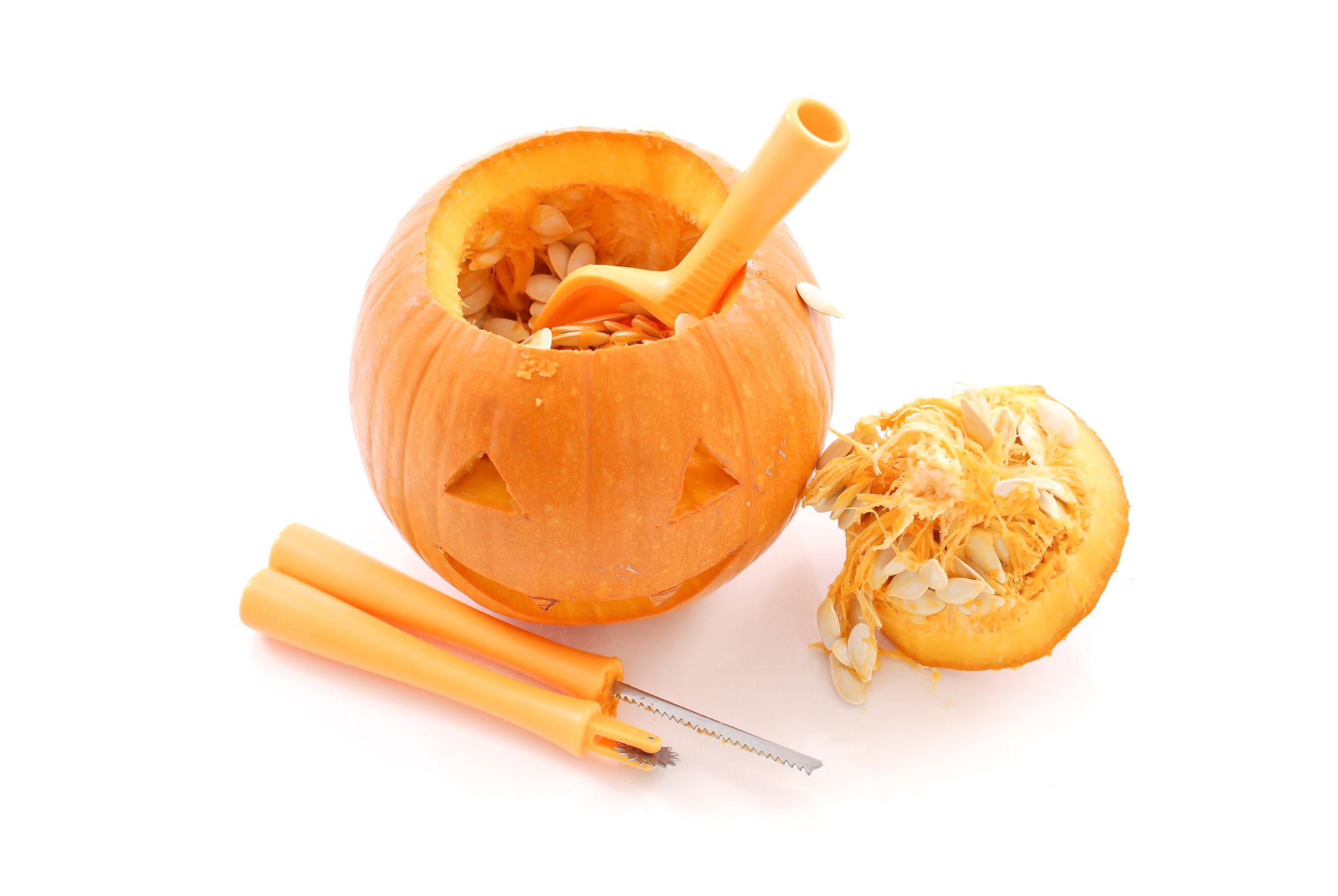 A pumpkin is depicted mid-carving, next to some tools.