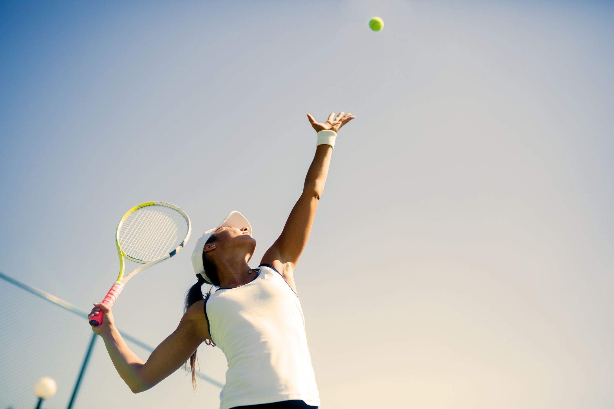 A female tennis player prepares to serve the ball during a match.