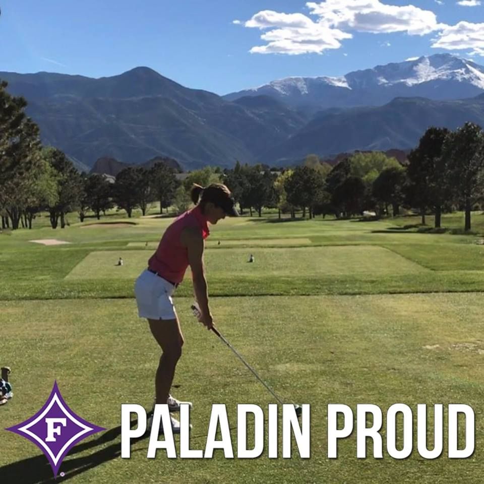 A female golfer prepares to hit her drive.