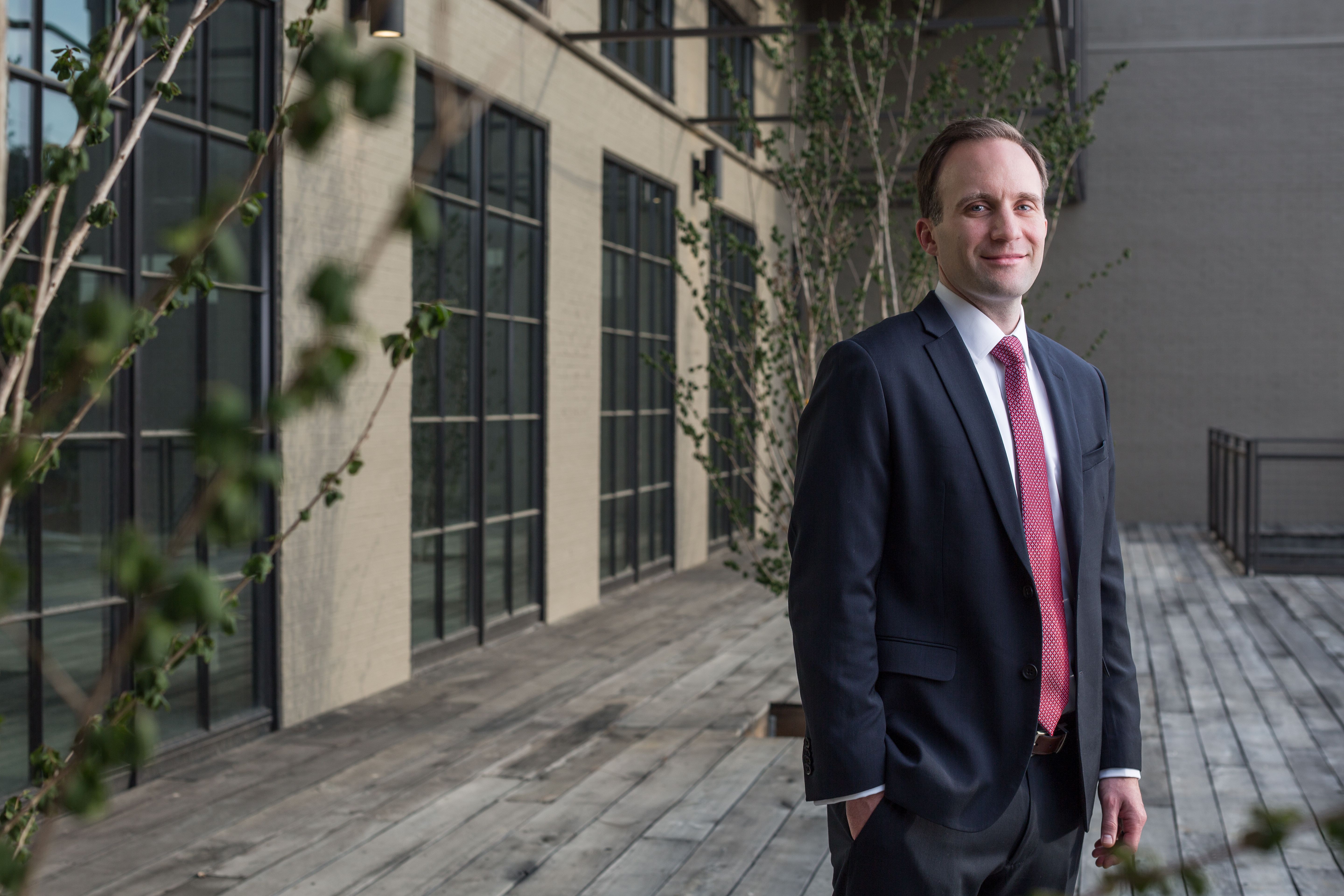 Dr. Christopher Blanchard poses in a courtyard.