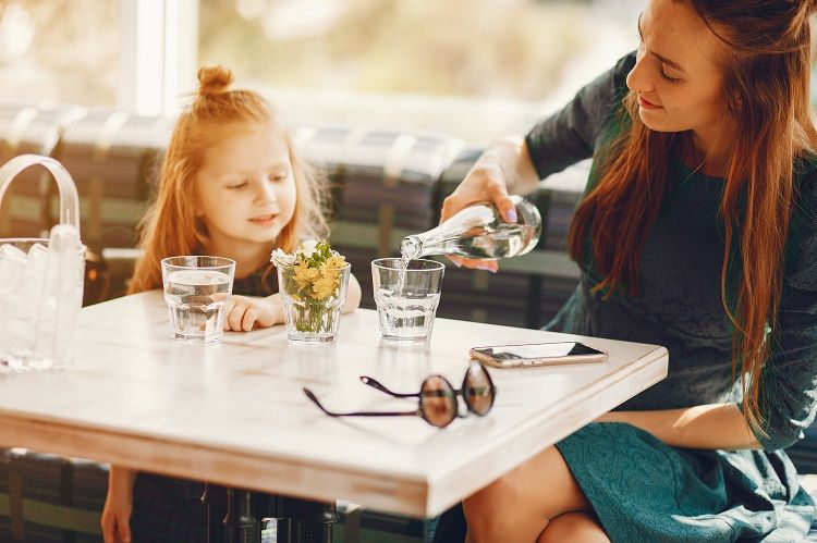 Mom and Daughter at Restaurant Table Drinking Water