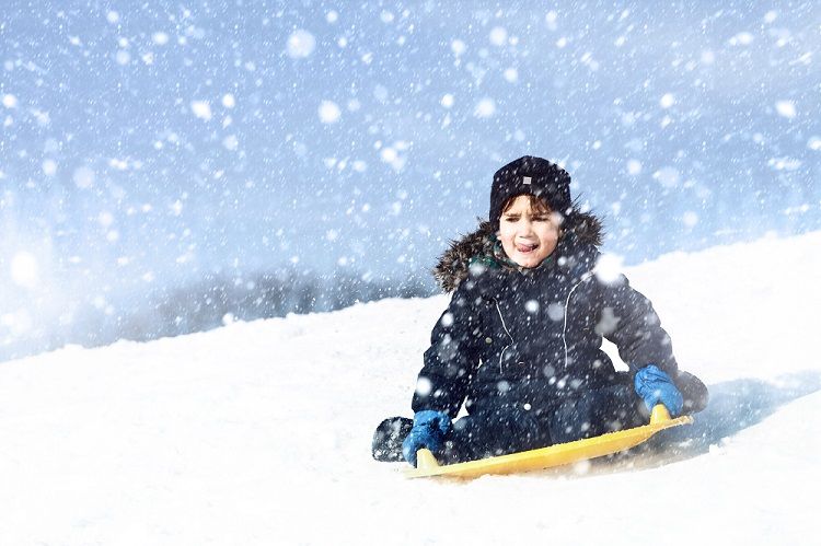 Child sledding down hill