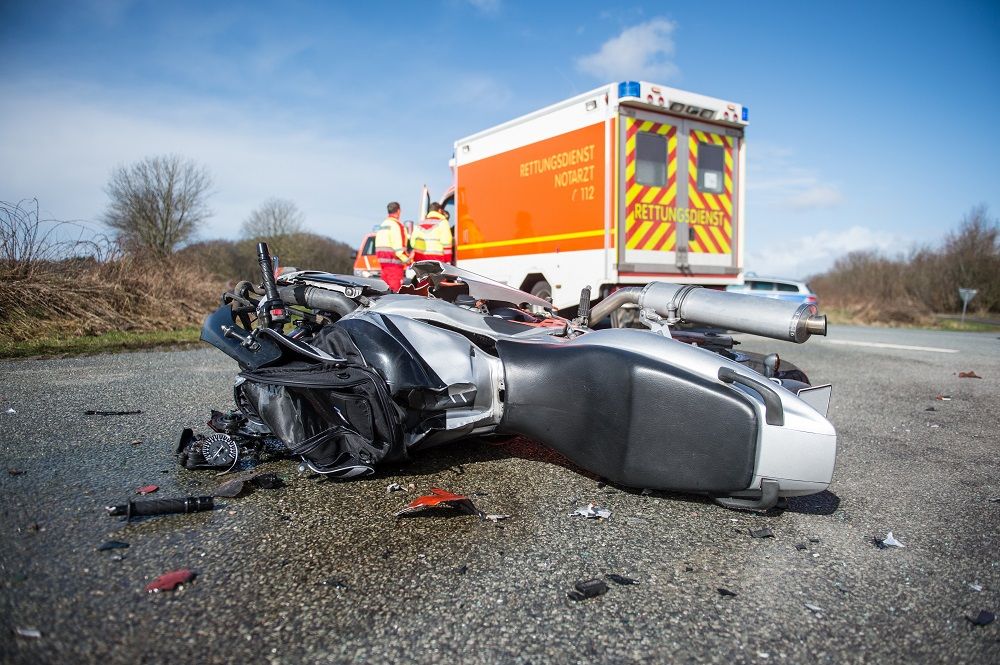 Motorcycle on the Ground in Front of Ambulance