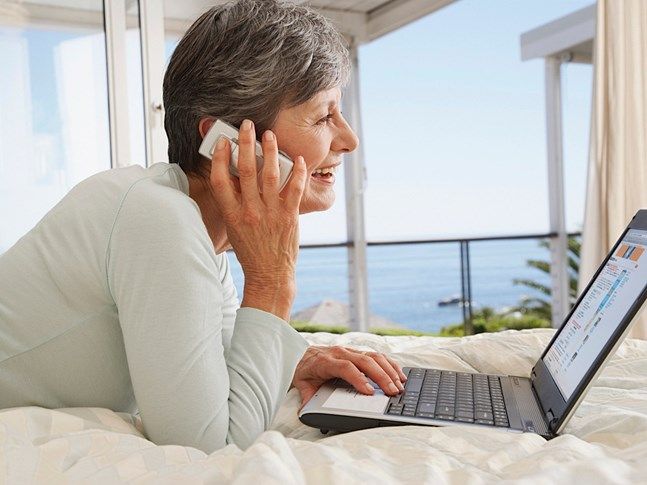 Smiling woman on phone using computer