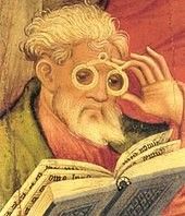 Man reading book wearing an early form of glasses