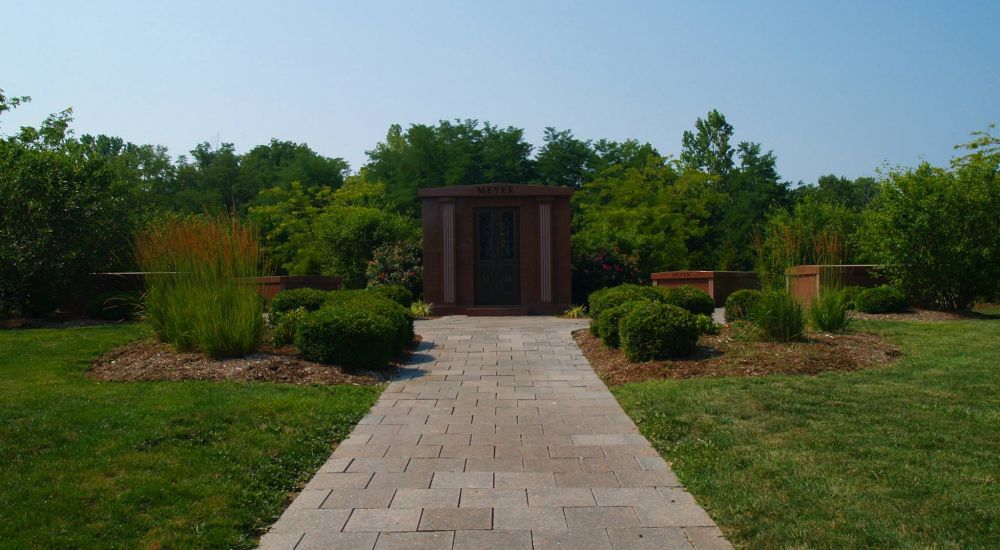 a brick pathway with grass and trees