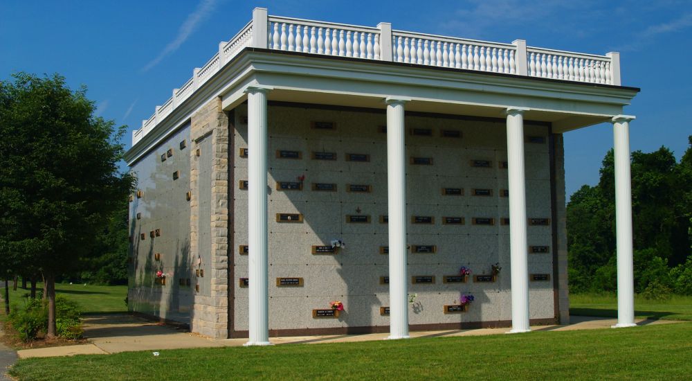 a building with columns and a grass lawn