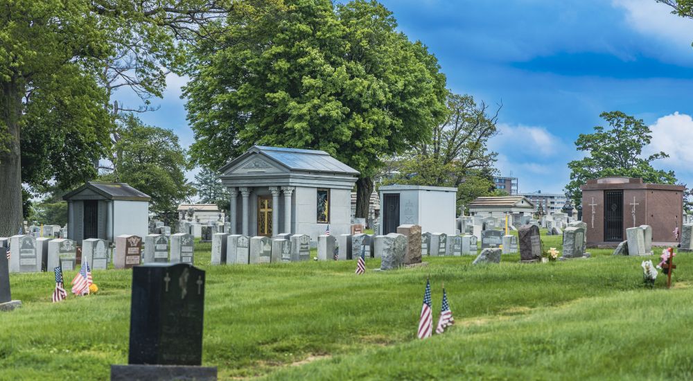 a cemetery with tombstones and flags