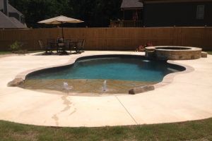 A gunite pool with a walk-in beach entry and spillover spa.