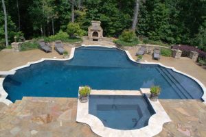 A resort lifestyle showcasing a gunite pool, spillover spa, and outdoor fireplace.